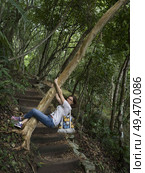 Woman hanging on tree in forest, Chaa Creek Road, Chaa Creek Nature Reserve, San Ignacio, Belize. Стоковое фото, агентство Ingram Publishing / Фотобанк Лори