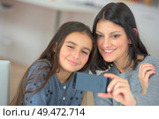 cute child and mother make selfie on new mobile phone. Стоковое фото, агентство Ingram Publishing / Фотобанк Лори