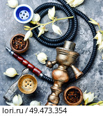 Smoking hookah with floral tobacco flavor.East kalian.Tobacco pipe and smoking tobacco with yucca flavor. Smoking pipe and floral tobacco. Стоковое фото, агентство Ingram Publishing / Фотобанк Лори