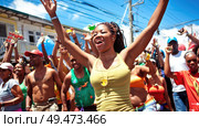 A woman with outstretched arms rejoices amidst a crowd during a vibrant street festival. Стоковое AI-изображение, AI-художник Данила Большаков / Фотобанк Лори