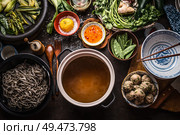 Various asian food ingredients for tasty soba noodles soup around cooking pot with delicious miso broth or stock on rustic kitchen table background, top view. Asian cuisine background. Healthy eating. Стоковое фото, агентство Ingram Publishing / Фотобанк Лори