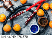 Hookah mouthpiece.Fruit shisha aroma.Tabak with apricot flavor.Kalian smoking with apricot. Smoking arab hookah with apricots. Стоковое фото, агентство Ingram Publishing / Фотобанк Лори