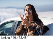 Young woman applying sunscreen on her face in snowy mountains in winter, in Sierra Nevada, Granada, Spain. Female wearing winter clothes.. Young woman applying sunscreen on her face in snow landscape. Стоковое фото, агентство Ingram Publishing / Фотобанк Лори