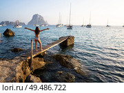 Ibiza cala d Hort girl on pier sunset Es Vedra islet Balearic Islands. Стоковое фото, агентство Ingram Publishing / Фотобанк Лори