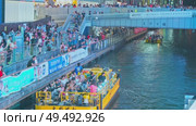 Osaka, Japan - Sep 21 2024, 4k, Panoramic view of Dotonbori river with a ship with tourists, a lot of people on embankment, there are a lot of advertising and illuminations on buildings, Osaka, Japan. Редакционное видео, видеограф Сергей Богомяко / Фотобанк Лори