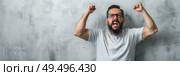 A man with a beard and glasses is standing with his fists raised in a confident gesture. Стоковое AI-изображение, AI-художник Данила Большаков / Фотобанк Лори
