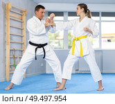 Sparring woman and man in white kimono during karate training in gym. Стоковое фото, фотограф Яков Филимонов / Фотобанк Лори