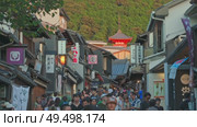 Kyoto, Japan - Sep 24 2024, 4k, panoramic view of street Kiyomizu-Zaka with many souvenir shops, tourists walking to temple of Pure Water Kiyomizu Dera, whose pagoda visible in distance, Kyoto, Japan. Редакционное видео, видеограф Сергей Богомяко / Фотобанк Лори