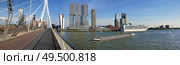 Cityscape panorama from Erasmus bridge over Meuse river in Rotterdam, the Netherlands. Tall modern buildings on the horizon and big ships crossing the Erasmusbrug canal. Стоковое фото, агентство Ingram Publishing / Фотобанк Лори