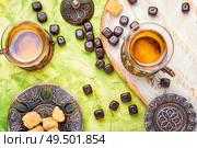 Eastern tea concept.Eastern tea in traditional glass with chocolate candy. Turkish tea in traditional glass. Стоковое фото, агентство Ingram Publishing / Фотобанк Лори
