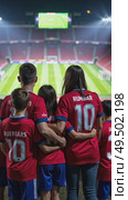 A portrait of a family at a fan zone, parents and children all wearing matching jerseys, their faces lit by the glow of a giant screen showing a sport game. Стоковое AI-видео, аниматор Sergey Grishin / Фотобанк Лори