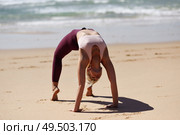 Caucasian woman practicing yoga at seashore. Young female standing in bridge pose in the beach in Cadiz, Andalusia, Spain.. Caucasian blonde woman practicing yoga in the beach. Стоковое фото, агентство Ingram Publishing / Фотобанк Лори