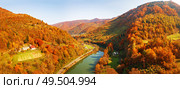 Mountain river flows in autumn colored valley. Panorama of road and village in river canyon. Sunny fall day in Carpathian mountains on border with Poland and Slovakia, Ukraine. Стоковое фото, агентство Ingram Publishing / Фотобанк Лори