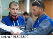 two experts talking while supervising plans. Стоковое фото, агентство Ingram Publishing / Фотобанк Лори