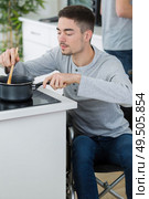 disabled young man in wheelchair in the kitchen. Стоковое фото, агентство Ingram Publishing / Фотобанк Лори