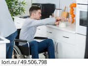 young handicapped man in the kitchen. Стоковое фото, агентство Ingram Publishing / Фотобанк Лори