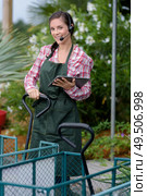 female worker in garden center wearing headset. Стоковое фото, агентство Ingram Publishing / Фотобанк Лори