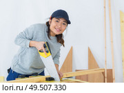 beautiful young woman working with saw. Стоковое фото, агентство Ingram Publishing / Фотобанк Лори