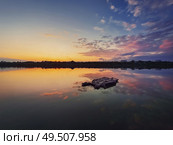 Fine art shot with an old, rusty catamaran frame forgotten on the pond. Scenery landscape, peaceful sunset sky background with colorful clouds reflection on the lake water. Стоковое фото, агентство Ingram Publishing / Фотобанк Лори