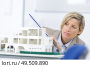 scale model of house and female architect woman in background. Стоковое фото, агентство Ingram Publishing / Фотобанк Лори