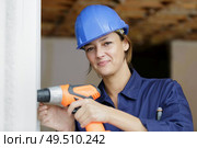 woman builder working with driller and window. Стоковое фото, агентство Ingram Publishing / Фотобанк Лори