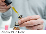 e-liquid being put into a vaporizer via a pipette. Стоковое фото, агентство Ingram Publishing / Фотобанк Лори