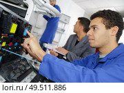 apprentice is learning to fix a printer. Стоковое фото, агентство Ingram Publishing / Фотобанк Лори