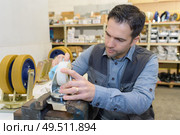 man fixing wheels of shopping cart. Стоковое фото, агентство Ingram Publishing / Фотобанк Лори