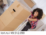 woman struggling carrying heavy carton box with furniture. Стоковое фото, агентство Ingram Publishing / Фотобанк Лори