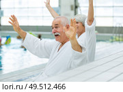 senior couple waving in a swimming pool. Стоковое фото, агентство Ingram Publishing / Фотобанк Лори
