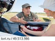 man asking a question to woman in glider. Стоковое фото, агентство Ingram Publishing / Фотобанк Лори