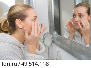 woman in her thirties checking her face for wrinkles. Стоковое фото, агентство Ingram Publishing / Фотобанк Лори