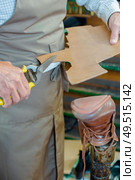 Cobbler cutting out new sole for boot. Стоковое фото, агентство Ingram Publishing / Фотобанк Лори