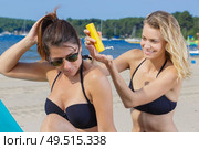 woman applying suncream to her friends back. Стоковое фото, агентство Ingram Publishing / Фотобанк Лори