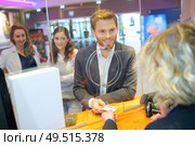 suited man buying ticket at booth. Стоковое фото, агентство Ingram Publishing / Фотобанк Лори