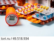 Pile of colorful medical pills in blisters and bottles on blue background. Drug and antibiotics prescription for treatment medication.. Pile of pills. Стоковое фото, агентство Ingram Publishing / Фотобанк Лори