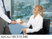 The beautiful business woman at office accepts a cup of coffee from the colleague. Стоковое фото, агентство Ingram Publishing / Фотобанк Лори