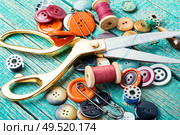 Sewing tools, scissors, buttons and threads on wooden table. Sewing supplies on wooden table. Стоковое фото, агентство Ingram Publishing / Фотобанк Лори