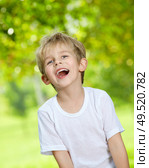 Portrait of the laughing loudly boy against a summer garden. Стоковое фото, агентство Ingram Publishing / Фотобанк Лори