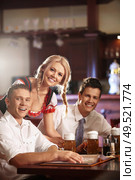 Waitress in a German national costume next to a pub visitors. Стоковое фото, агентство Ingram Publishing / Фотобанк Лори