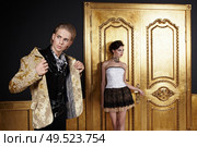 The young man puts on, the girl costs at a door. Стоковое фото, агентство Ingram Publishing / Фотобанк Лори