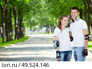 Young enamoured couple on rollers in park. Стоковое фото, агентство Ingram Publishing / Фотобанк Лори