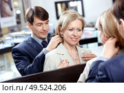 The man clasps a jeweller necklace to the woman. Стоковое фото, агентство Ingram Publishing / Фотобанк Лори