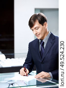 The businessman of average years signs papers. Стоковое фото, агентство Ingram Publishing / Фотобанк Лори