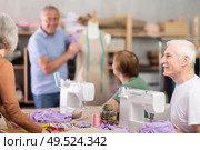 Elderly male teacher showing how to sew on mannequin. Стоковое фото, фотограф Яков Филимонов / Фотобанк Лори