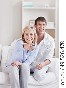 The girl next to a man switches TV channels. Стоковое фото, агентство Ingram Publishing / Фотобанк Лори