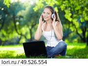 Girl with headphones and a laptop in the park. Стоковое фото, агентство Ingram Publishing / Фотобанк Лори