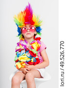 Funny beautiful party little girl in disguise with wig in many colors and pink round sunglasses. Funny little girl in disguise with wig and sunglasses. Стоковое фото, агентство Ingram Publishing / Фотобанк Лори