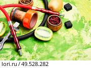 Arabic smoking hookah with taste of kiwi.Fruit shisha tobacco. Tobacco with taste of kiwi.Oriental tobacco hooka.Space for text. Oriental shisha with kiwi flavor. Стоковое фото, агентство Ingram Publishing / Фотобанк Лори