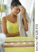young woman in bathroom mopping her brow with towel. Стоковое фото, агентство Ingram Publishing / Фотобанк Лори